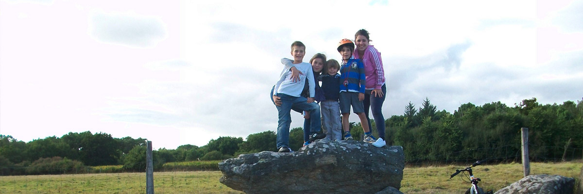 Marta con sus hijos invitados en una piedra.