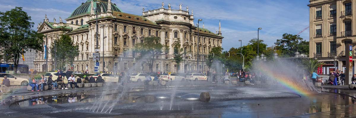 The fountain and the sunlight create a little rainbow in the city centre of Munich