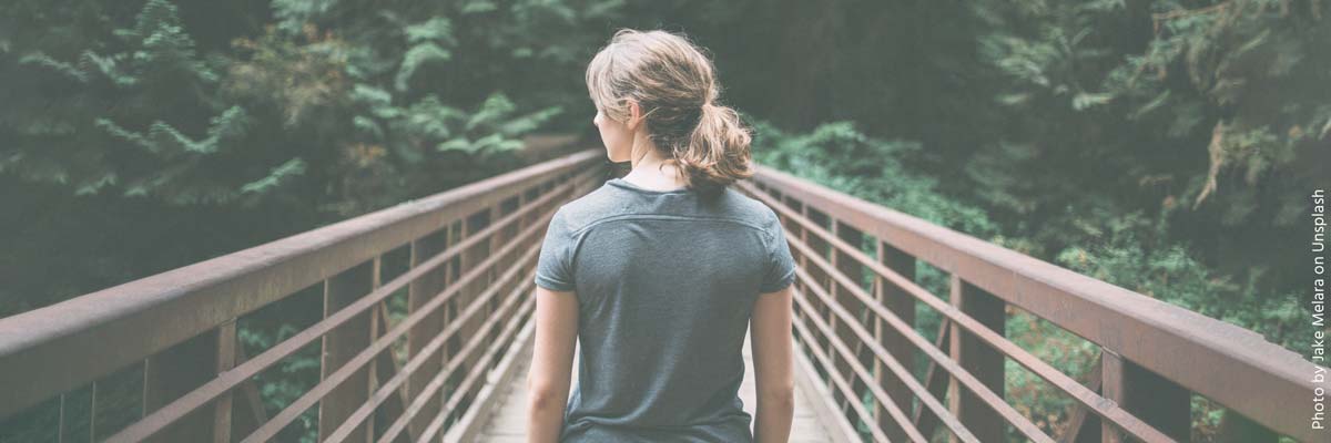 Jonge vrouw die over een brug loopt