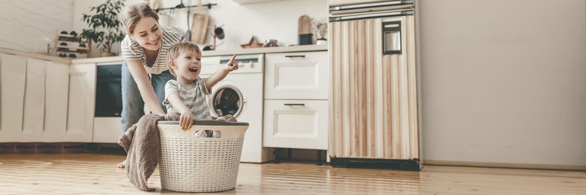 Au-pair haciendo las tareas domésticas con un niño