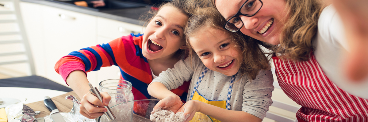 Children help with family cooking in the kitchen.