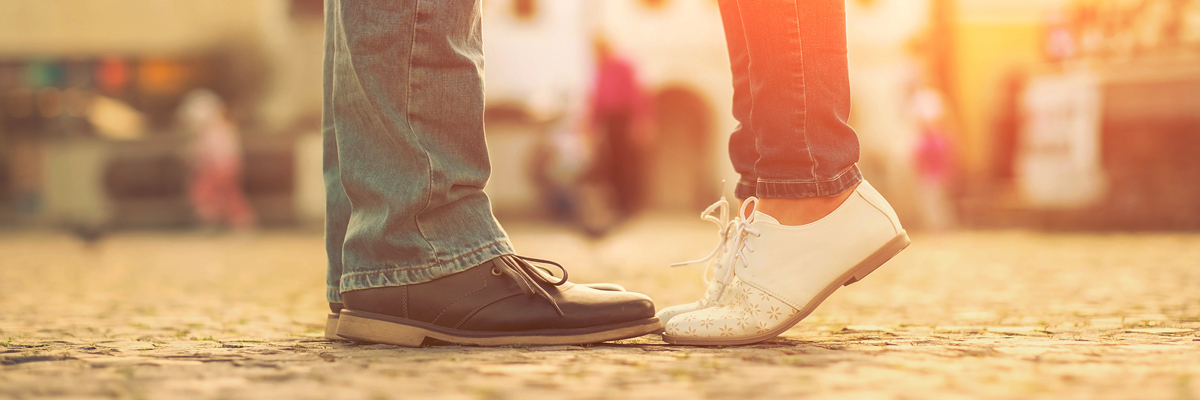 Close-up on the feet of a young couple as they embrace.