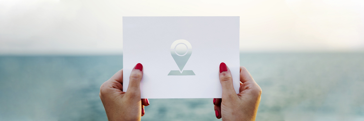 Woman's hands holding card with location icon