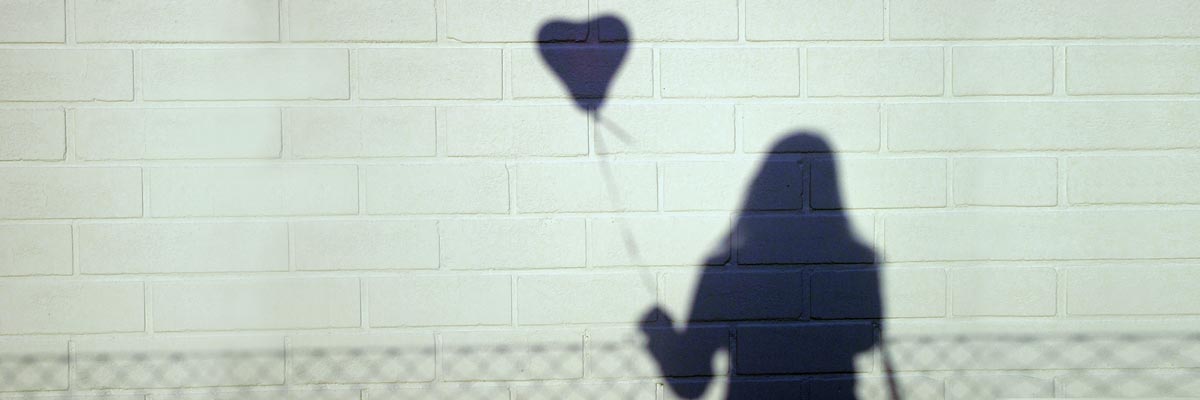 shaddow of a girl with a heart ballon in her hand