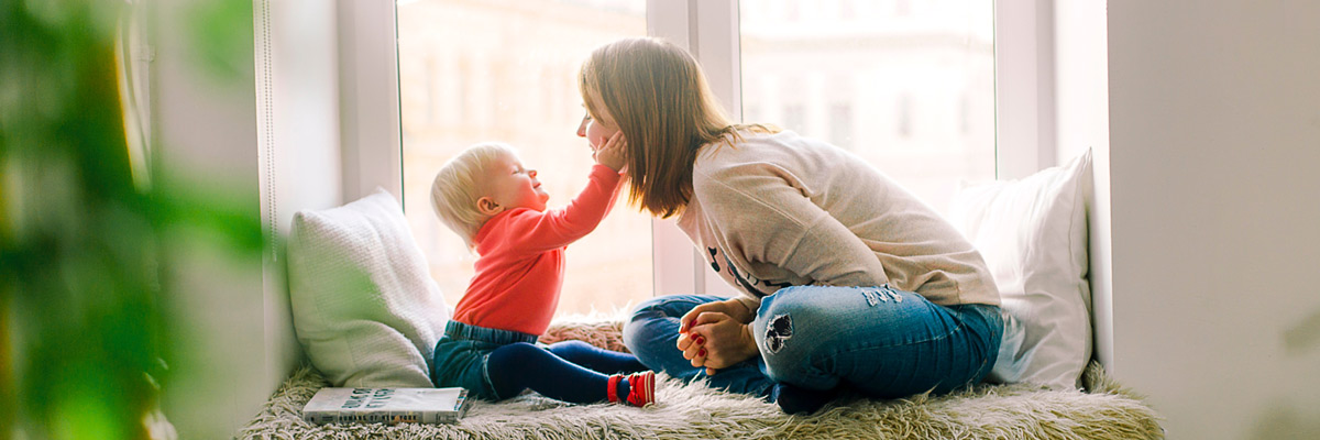bambino e au pair che giocano alla finestra