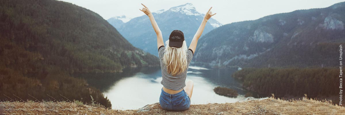 Woman in front of a lake and mountains