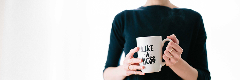 Woman with cup of coffee with text "like a boss"
