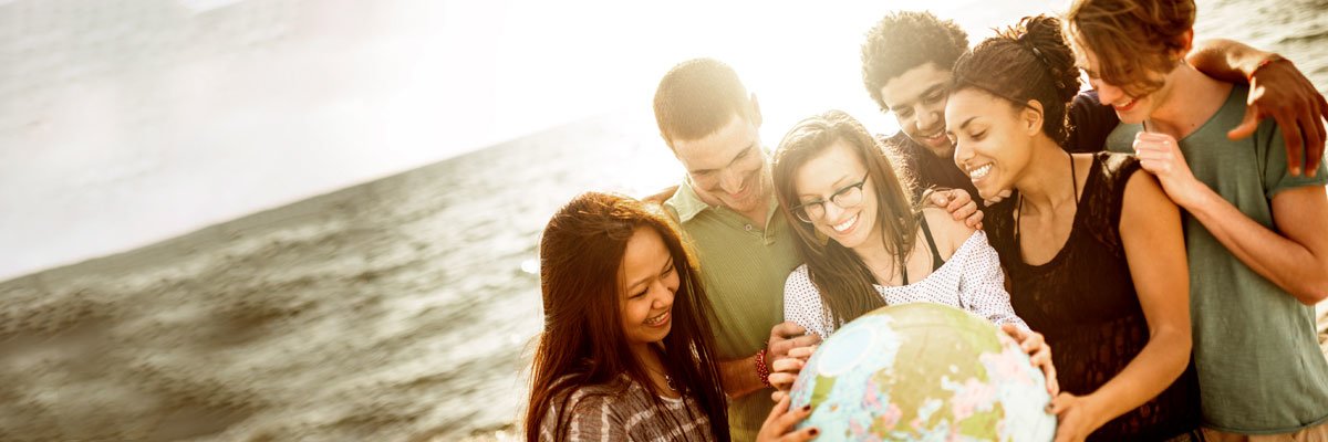 A group of young people point to a water ball globe