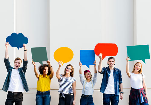 Young people hold speech bubbles in the air
