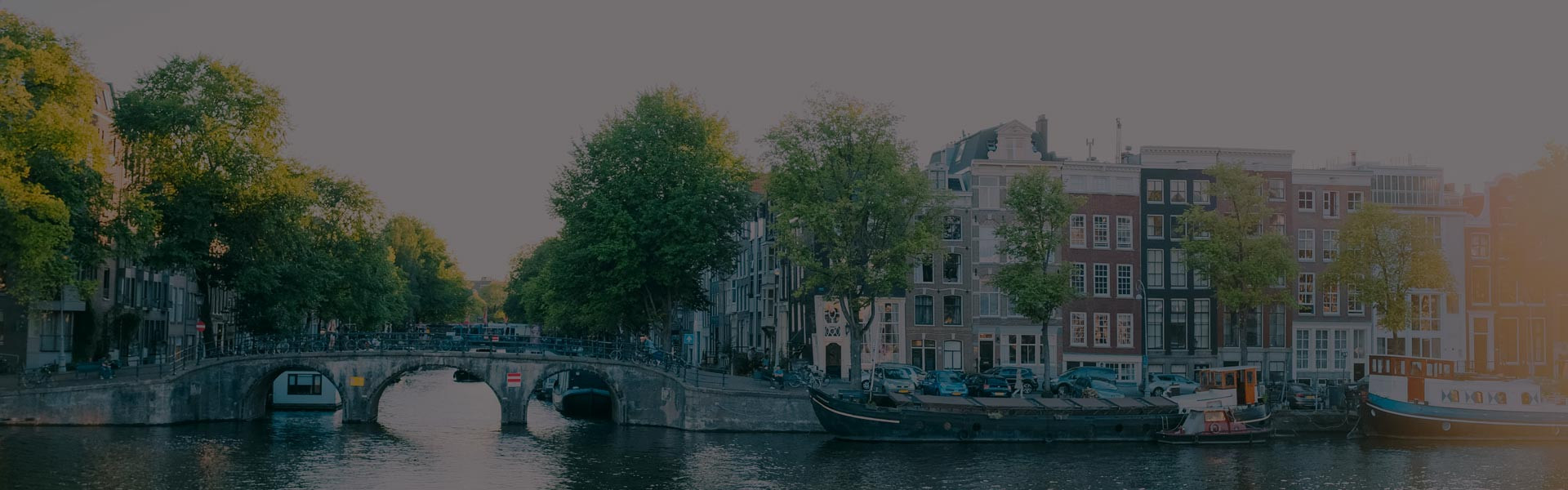 Gracht in Amsterdam mit charismatischen Häusern im Hintergrund