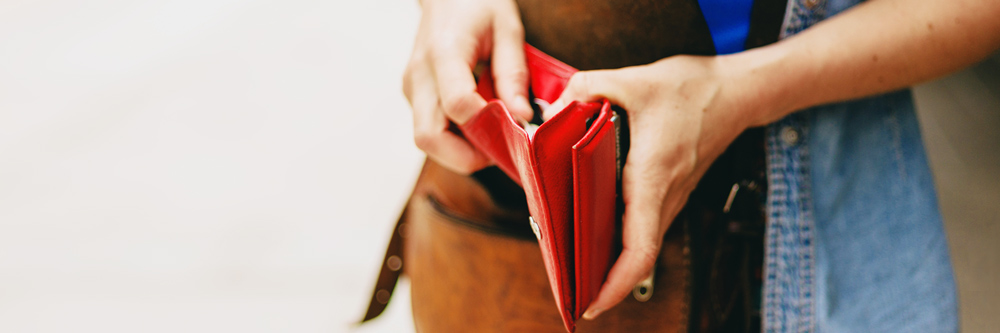 Taschengeld, junge Frau hält eine Geldbörse in der Hand