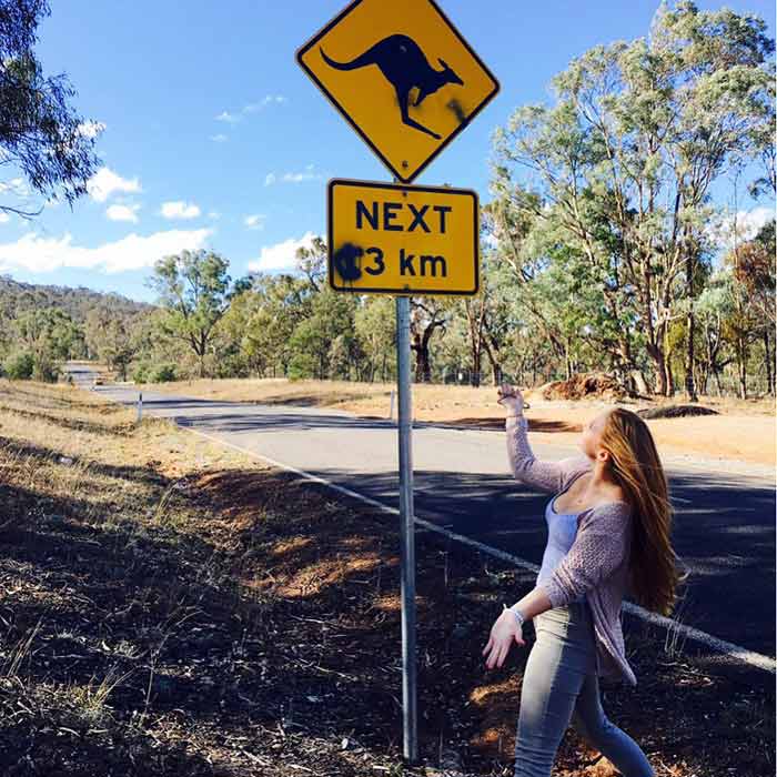 Au-pair Nina unter einem Straßenschild