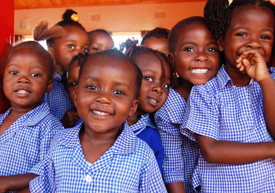 Kinder in afrikanischer Schule lachen in die Kamera