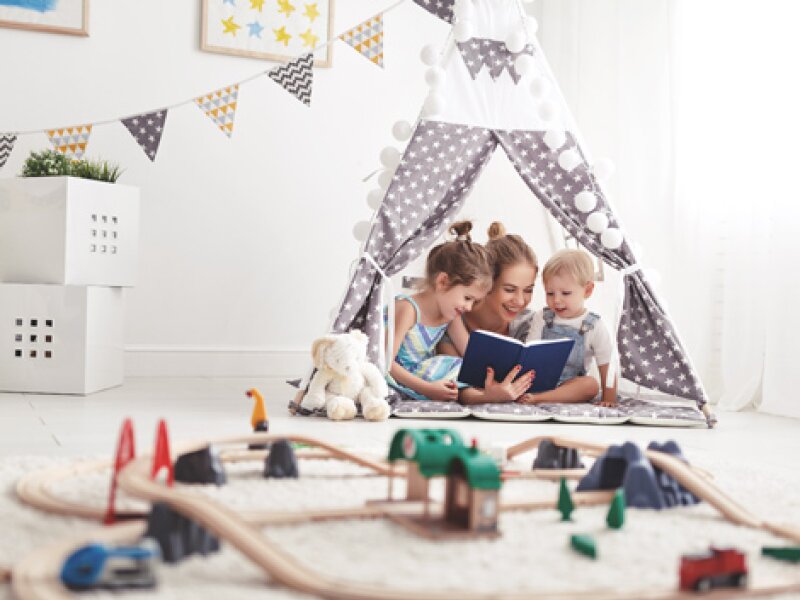 Een meisje met twee kinderen onder de tent