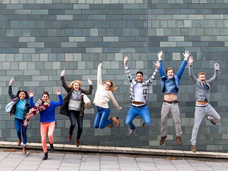 Happy young people jumping upwards