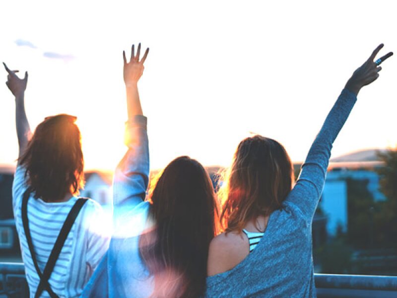 Three young women look into the sunset