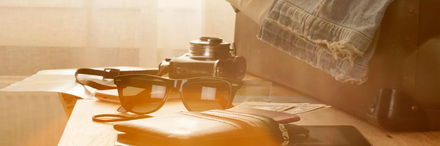 Suitcase, sunglasses, passport and notebook