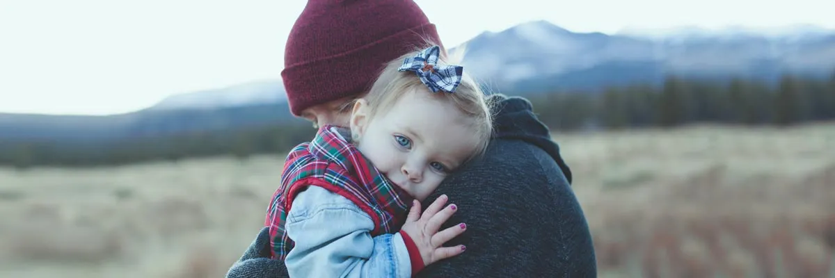 A parent holds their child in their arms