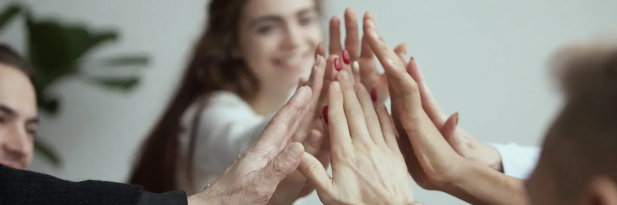 A group of people put their hands together to show their bond