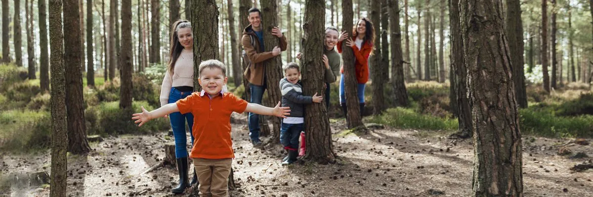 Eine Familie spielt Verstecken in einem Wald