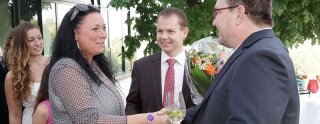 Sommige gasten met een boeket bloemen begroeten Uwe Regenbogen