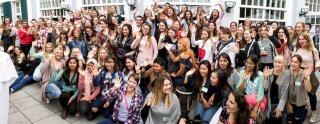 Les jeunes assistant à la rencontre sourient et saluent la caméra