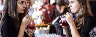 Ragazze alla pari che bevono dei cocktail alla frutta