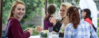 Trois filles parlent à l'extérieur du bâtiment