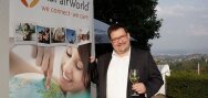 Uwe Regenbogen (Gründer von AuPairWorld) neben dem AuPairWorld-Banne