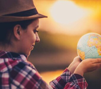 Chica joven con un globo del mundo en las manos