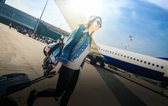 Jonge vrouw met koffer op de luchthaven
