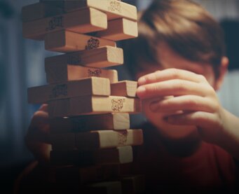 Kleine jongen achter een Jenga spel