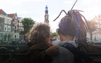 Jonge vrouw met kind op brug in Amsterdam