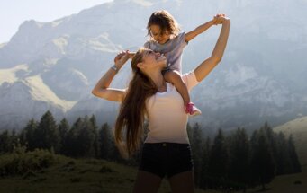 Una au pair con un niño en la montaña