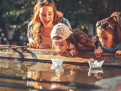 Woman an two Kids playin with paperships