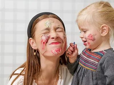 a child is coloring a womans face