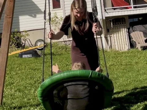 Jessica pushing her host kid on a swing