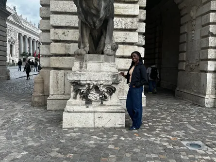 Toun posing next to a statue