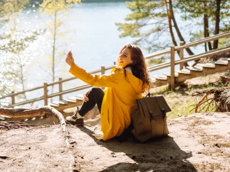 Young girl taking a selfie on a lake