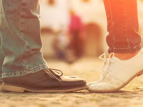 Close-up on the feet of a young couple as they embrace.