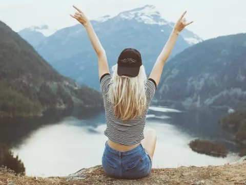 Donna di fronte a un lago e alle montagne