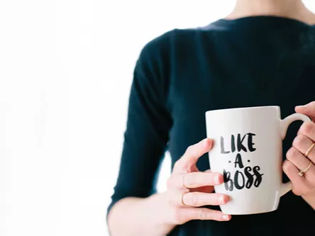 A person holds a mug that reads 'Like a boss'