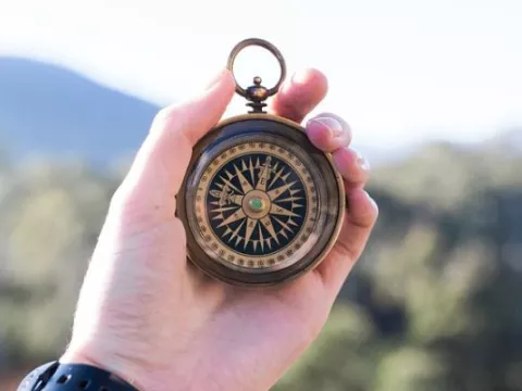 Hand holding a compass