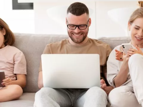Family on the sofa with laptops