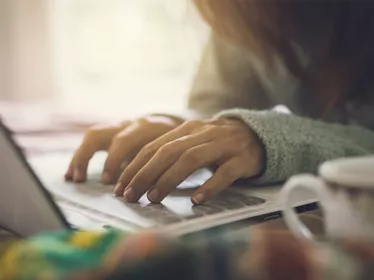 Een paar handen typen op een laptoptoetsenbord