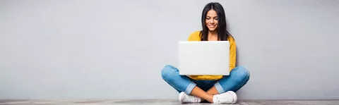 Frau mit Laptop auf dem Schoß