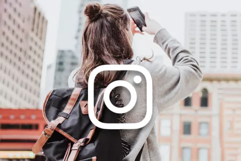 Frau macht Foto mit Instagram Logo