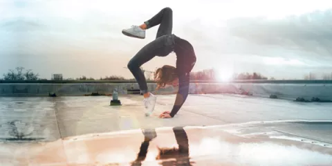 Babbel - Junge Fraue macht Handstand