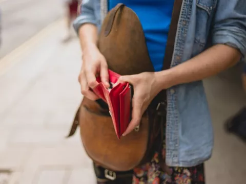 Frau mit offenem Portemonnaie in der Hand