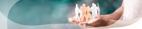 Hands holding diverse paper figures in unity, blue background.